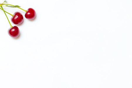 Ripe cherries on a white leaf in the upper left corner. Template for your designの写真素材