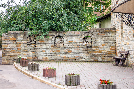 An old-style stone fence near a building in a modern cityの写真素材