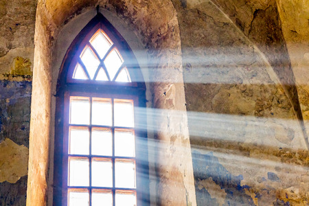 Bright light penetrates through the window of an ancient templeの写真素材