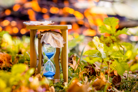 Sandy hour on the background of a fire in the forest in the fall. A symbol of the fast flow of timeの写真素材