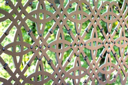 A fragment of an iron ornamental lattice in a city parkの写真素材