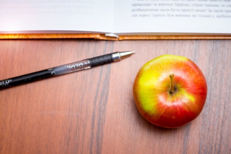 An apple in front of an open book, a top viewの写真素材