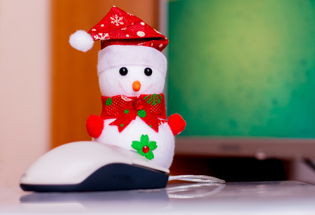Toy snowman at the computer. Close-up.  Work in the office in the winterの写真素材