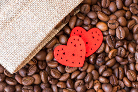 Red hearts against the background of coffee beans. Love for coffeeの写真素材