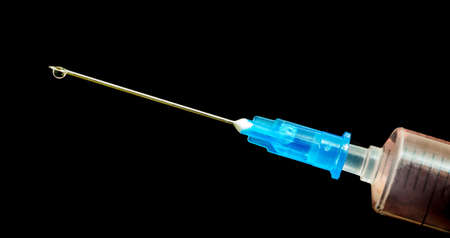 Injection syringe on black isolated background. Healthcareの写真素材