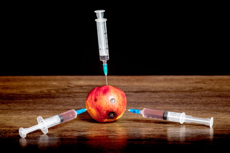 Three syringes are inserted into the apple with rot traces. Adoption of drugs. The problem of drug...