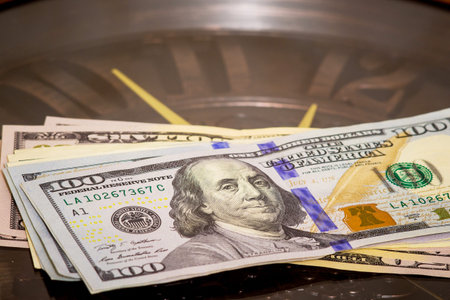 Dollars lie on the big clock. Time to earn money. Getting a salary.Time is money