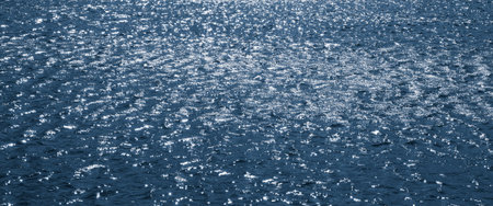 Background, texture from dark waves, in which the sun reflects. Dark waves on the surface of the...