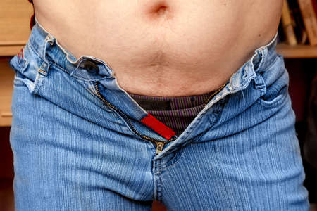 A man dress pants that are too tight and can not be fastened due to overweight. Concept - obesity, overweightの写真素材