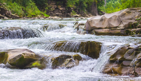 Mountain river with a small waterfall in summer. Waterfall in Yaremche, Ukraine