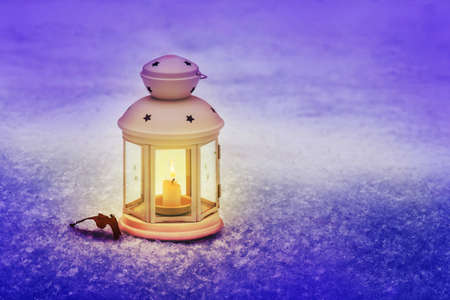 Lantern with candle on the snow on a winter Christmas evening. Celebrating New Year outdoorsの写真素材