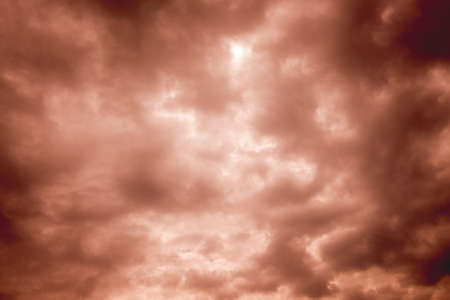 Dark storm clouds with flashes of light at sunsetの写真素材
