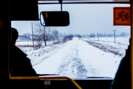 Winter road from bus window. Winter motor vehicle travelの写真素材