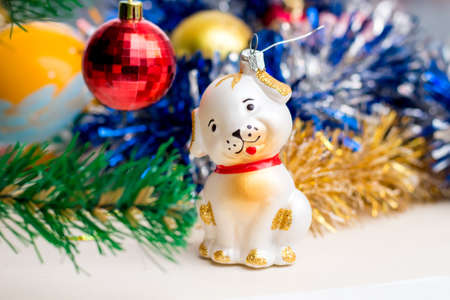 Toy dog near Christmas tree. Christmas toys. New Year greetingsの写真素材
