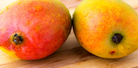 two mango on carving board
