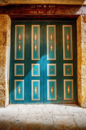 Green vintage door spotlit by sunlight, Besalu, Spainの写真素材
