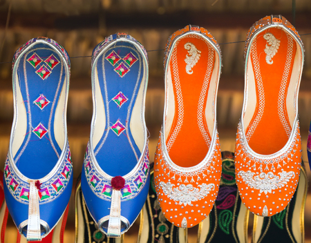 Blue and orange colorful ethnic shoes on flea market in Indiaの写真素材