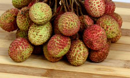 Bunch of lychee on old wooden cutting boardの写真素材