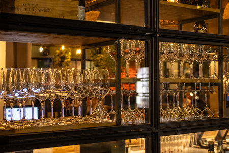 A close-up shot showcases a meticulously arranged display of elegant wine glasses within a stylish...