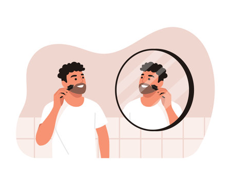 Vector illustration of a handsome man shaving his beard. Cartoon scene of a smiling man with curly hair, shaving with a beard trimmer, looking into a round mirror isolated on a white background.のイラスト素材
