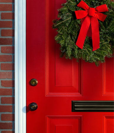 Christmas wreath on red paneled door with knob, lock and mail slotの写真素材