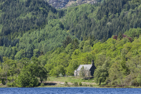 A lonely old church in Scotland near a lake surrounded by a large vast forest.の写真素材