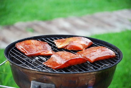Salmon steaks cooking on a charcoal grillの写真素材