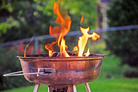 Flames shooting from a newly lit charcoal grillの写真素材