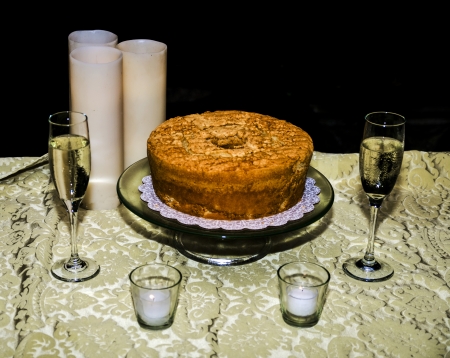White Tablecloth Black Background Wine Glasses and Cakの写真素材