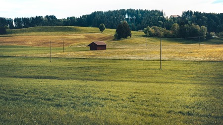 Wooden cottage on the green meadow field in natureの写真素材
