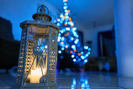 Christmas Lantern with decorations on marble floor. Christmas Tree in background, night and blueの写真素材