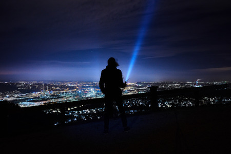 flashlight is shining up to the sky on a hill near Stuttgart Rotenberg during the night, cloudsの写真素材