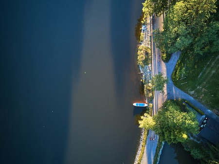Top View of a small lake and green trees around with a small path or streetの写真素材