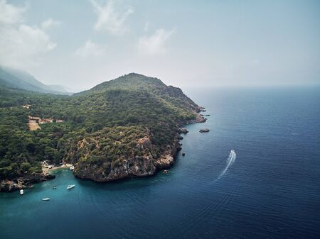 turkey, aerial drone perspective of deep blue and turquoise water of the mediterranean sea. Moody weather with many green trees. nice sandy white yellow beachの写真素材