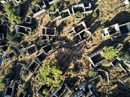 Historical Lycian village of Kayakoy, Fethiye, Mugla, Turkey. Drone aerial shot from above of the Ghost Town Kayakoy. Greek Village. Evening moody warm sun of the ancient city of stoneの写真素材