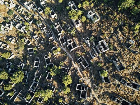 Historical Lycian village of Kayakoy, Fethiye, Mugla, Turkey. Drone aerial shot from above of the Ghost Town Kayakoy. Greek Village. Evening moody warm sun of the ancient city of stoneの写真素材