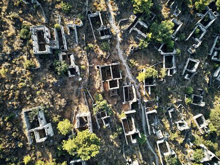 Historical Lycian village of Kayakoy, Fethiye, Mugla, Turkey. Drone aerial shot from above of the Ghost Town Kayakoy. Greek Village. Evening moody warm sun of the ancient city of stoneの写真素材