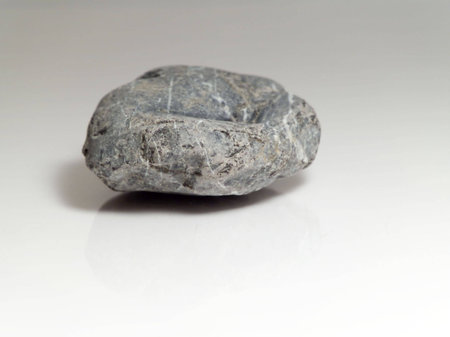 A grey stone on grey reflective backgroundの写真素材