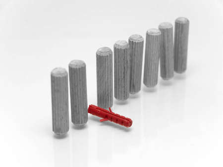 A red plastic dowel with wooden dowels on white backgroundの写真素材