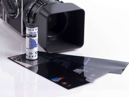 The photo shows a high end camera, a roll film and some slides over whiteの写真素材