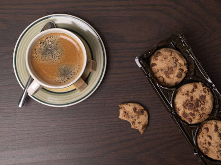 The photo shows some cookies and a cup of coffee on a tableの写真素材
