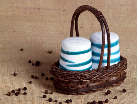 The photo shows a small basket with a muffineer and a pepper casterの写真素材