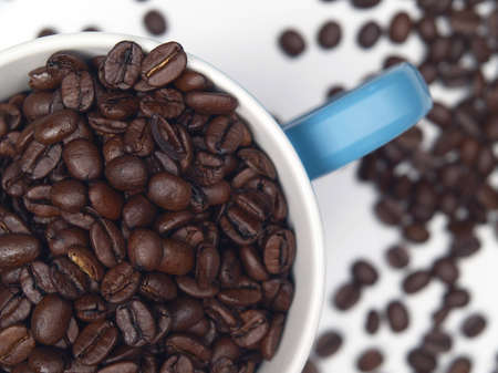 The image shows a part of a coffee cup filled with coffee beansの写真素材