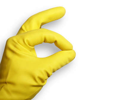 The image shows a human hand with a rubber glove over whiteの写真素材