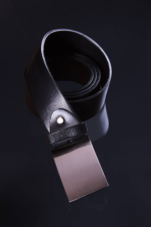 The image shows a black belt over black reflective backgroundの写真素材