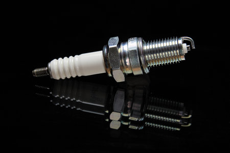 The image shows a spark plug over black background