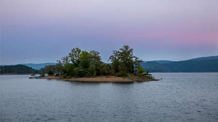 Late evening long exposure of lake with island pink skyの写真素材