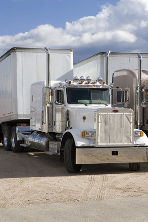 two large rigs sit ready to go in an industrial parking area