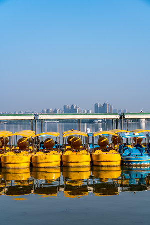 Yellow pedal boats in the lake, blue sky and city background.の写真素材