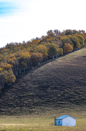 Autumn Landscape with a small house on a hillside.の写真素材